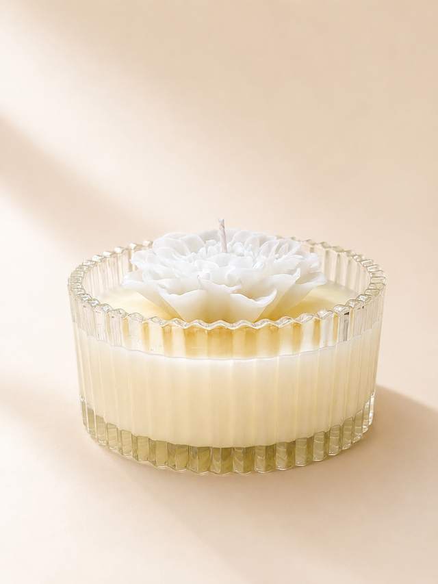White flower candle in a ribbed glass
