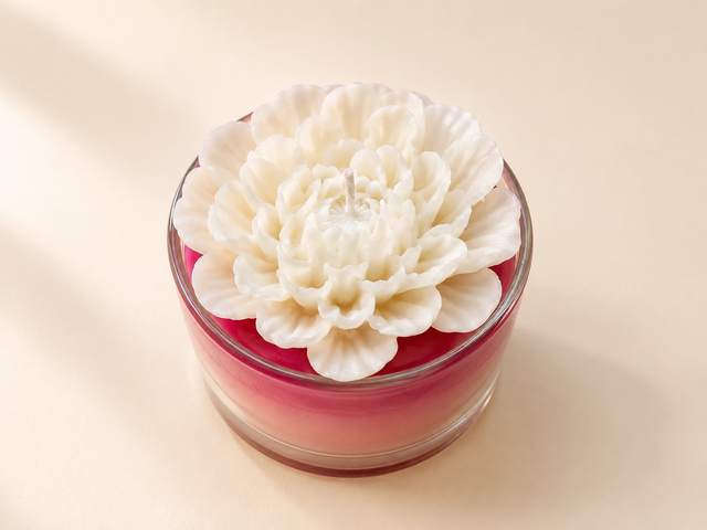White dahlia flower candle on pink wax